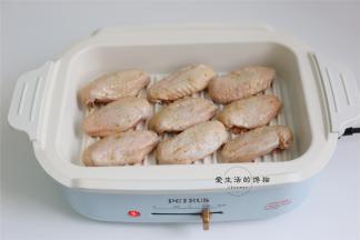 将鸡翅用厨房用纸吸干表面水份放入锅内煎，腌制的汁不要扔，留着还有用。