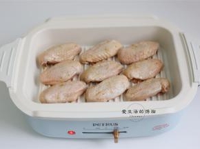 将鸡翅用厨房用纸吸干表面水份放入锅内煎，腌制的汁不要扔，留着还有用。