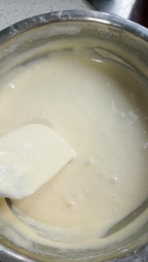 往刮刀上转圈快速倒入黄油与牛奶混合物!翻拌均匀!