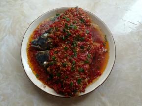 鱼头蒸熟后取出撒上葱花，小锅里放入10克油烧热，淋到鱼头上