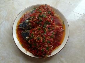 鱼头蒸熟后取出撒上葱花，小锅里放入10克油烧热，淋到鱼头上