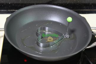 美亚平底锅，热锅，倒油，把心形煎蛋模具放入平底锅中央，用刷子刷一层油，刷油的模具脱模的时候不会粘。