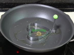 美亚平底锅，热锅，倒油，把心形煎蛋模具放入平底锅中央，用刷子刷一层油，刷油的模具脱模的时候不会粘。