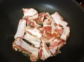 锅里热油，爆香姜丝，放入腌好的排骨煎至微黄