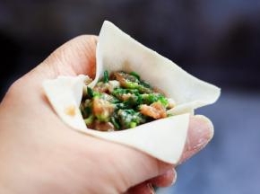 用手的虎口将云吞皮聚拢住馅料。