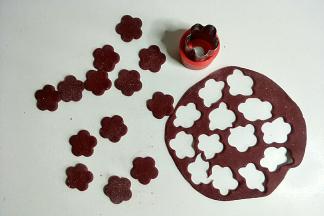 把面团擀成厚度为1mm左右的薄饼，用模具刻出花朵