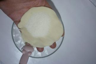 把面团按扁，包入白糖馅