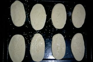 依次做好，摆入烤盘，每个之间留出一定的距离。刷一层清水，撒适量白芝麻