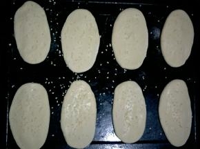 依次做好，摆入烤盘，每个之间留出一定的距离。刷一层清水，撒适量白芝麻