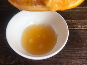 鲜橙洗净，切开两半，挤出橙汁