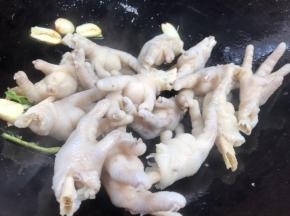 放入鸡爪，翻炒至干水