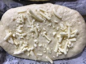 放入铺好油纸的烤盘上，撒上芝士