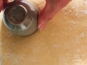 案板撒适量干粉，用手轻轻将面团按压成约一厘米厚度的均匀面饼，用一个圆形模具压出圆形小冰。