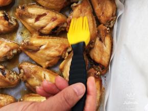 时间到，取出烤盘，将鸡翅翻面，刷烧烤汁，撒辣椒粉，再烤十分钟。