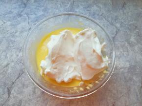 打发好的蛋白分成三份，取中间的三分之一加入到蛋黄糊里面，用硅胶刮刀采用切拌和翻拌的方法混合均匀。