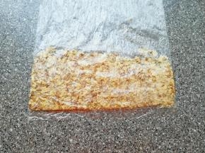 核桃仁装进保鲜袋里面，用擀面杖压碎。