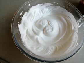 蛋清里分三次加入糖，用电动打蛋器打发至偏干性发泡的蛋白霜