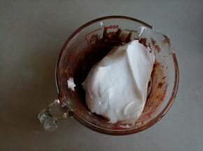 用刮刀取1/3打发好的蛋白霜到蛋黄糊里，从底部向上翻拌并切拌均匀