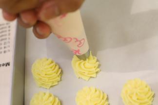 垂直拿起裱花袋，从中间向外面画圆圈挤，一边挤一边往上提，4圈为宜。