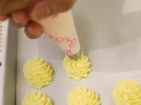 垂直拿起裱花袋，从中间向外面画圆圈挤，一边挤一边往上提，4圈为宜。