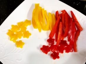 灯笼椒切条状和用刻模印出几朵小花，焯水备用