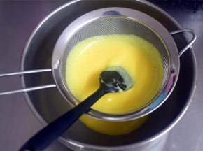 将蛋奶糊倒入奶锅中，中火加热，边煮边搅拌，煮至85度左右，离火并过筛备用。