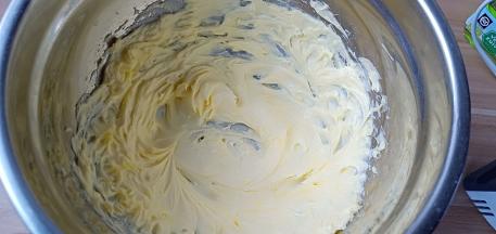 黄油用电动打蛋器低速打发至颜色变淡、体积膨大、呈羽毛状。