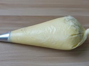 裱花袋装入8齿的裱花嘴、将面糊装入裱花袋、攥紧袋口。