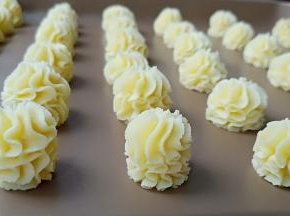 以竖直的方式挤出、在烤盘上挤出漂亮的曲奇花。