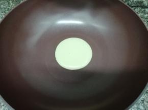 取出新思特不沾炒锅，稍微加热一下，然后舀一勺面糊倒入锅中，盖上锅盖