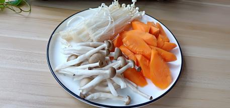 胡萝卜削皮切滚刀块、秀珍菇与金针菇掰开洗干净。