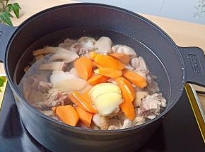 焯水过后的三黄鸡清洗干净，胡萝卜一起重新放锅里炖煮。