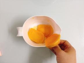 拿出一个杯子。然后把芒果切成两半，拿出一块芒果在杯子口，从下往上从杯子口划过，这样芒果肉就全掉在杯子里了，相当方便快速。