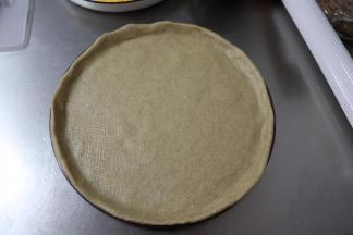 把面皮放入披萨盘内，调整均匀。
