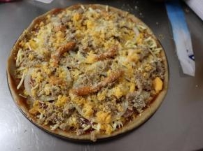 再铺上一层马苏里拉芝士碎，然后再铺上圆葱圈、金枪鱼，最后再来一层芝士碎，撒上披萨草、芝士粉，挤上少许的披萨沙拉酱，如果喜欢番茄酱的味道，还可以再来一点点番茄酱。