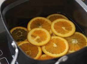 2. 先倒入300g水然后加入100g细砂糖，之后把切好的橙皮放进去，小火慢慢煮。注意翻面，我是用筷子小心的夹起翻面。火不可以太大，不然橙皮的果肉部分容易散