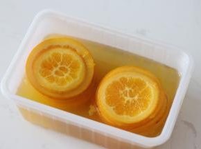 4. 煮好的橙片连同糖水一起装入保鲜盒，室温放凉后转入冷藏一夜。（不冷藏过夜也可以用，只是经过冷藏橙皮香味会更好）