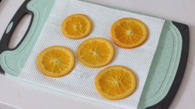 5. 取5片制作好的橙片，用厨房纸吸干多余水分。这一步很重要！！过多的水分会泡稀周围面糊，导致橙片不服贴以及部分蛋糕卷组织不佳