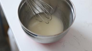 6. 【蛋糕卷部分】
将水和食用油秤量好之后，由中间向外同一方向画圈搅拌至完全乳化。