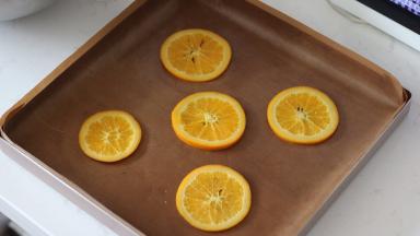 15. 烤盘中铺好油布，然后摆上5片橙片，不要摆的太靠边缘，会影响卷卷