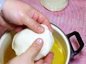 从玉米油中拿出饺子皮，10个饺子皮摞一起，挤出中间的油备用