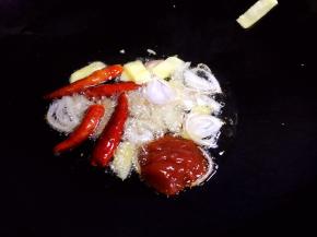 油锅烧热，放入毛葱、生姜、干辣椒爆香，放入番茄沙司炒匀