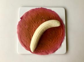 取一片薄饼，光面朝下，香蕉去皮，卷进薄饼里。