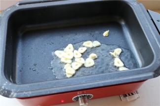 锅再次加热，加入油烧热，放入蒜片爆香。