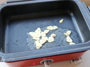 锅再次加热，加入油烧热，放入蒜片爆香。