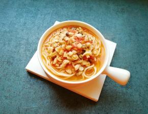 将面条盛入碗里，浇上茄汁菌菇汤。