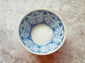 白砂糖放入小碗里，加入热水将糖化开，晾凉备用。