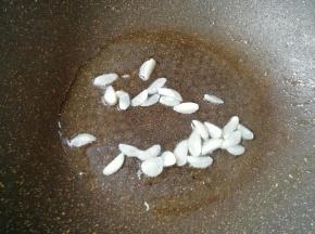 锅里重新倒油烧热，下入蒜片炒香。