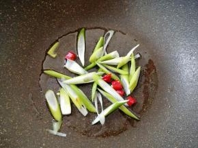 炒锅内倒适量的食用油烧热，下入葱丝和干红辣椒炒香。