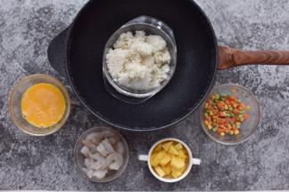 虾仁加白胡椒粉、盐稍加腌制，鸡蛋打散，菠萝切小块。